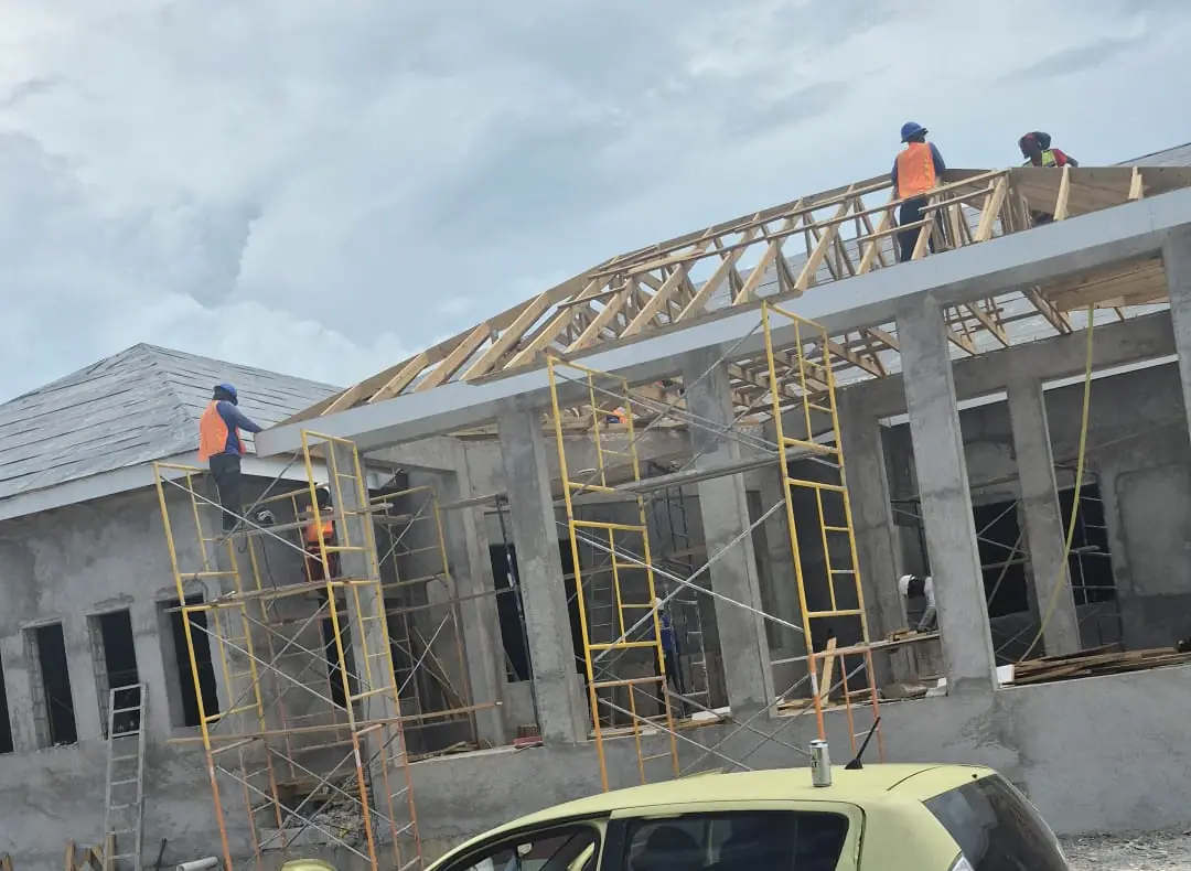 Overtime crew correcting and bracing a truss roof on scaffolding