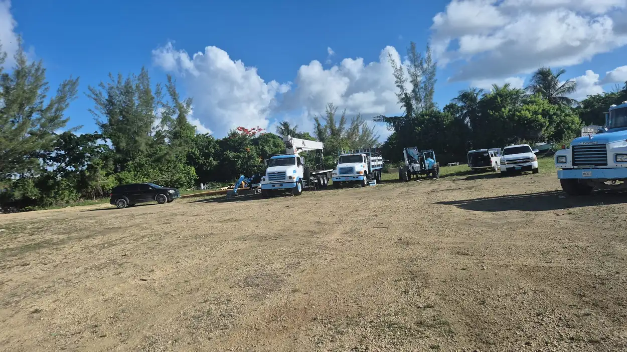 Overtime Roofing and Truss fleet — crane truck, flatbeds and telehandler at the Nassau yard